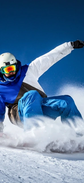 Snowboarder carving on blue sky