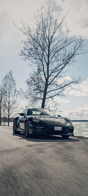 Black Porsche Driving by Lake
