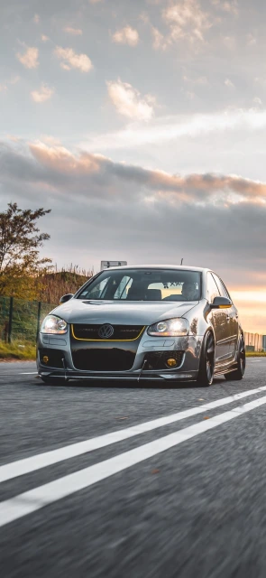 Silver Car Driving on Road at Sunset