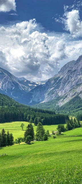 Green Valley With Mountains and Clouds
