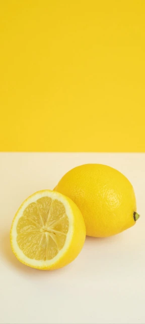 Two Lemons on Yellow Background