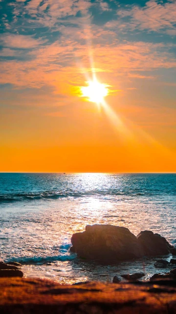 Sunset Over Ocean With Rocks